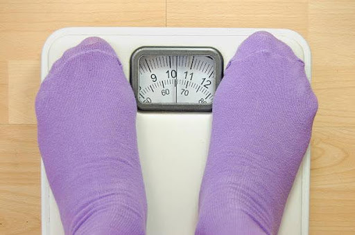 Feet standing on weighing scales